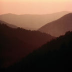 The mountains fold across each other into the sunset.